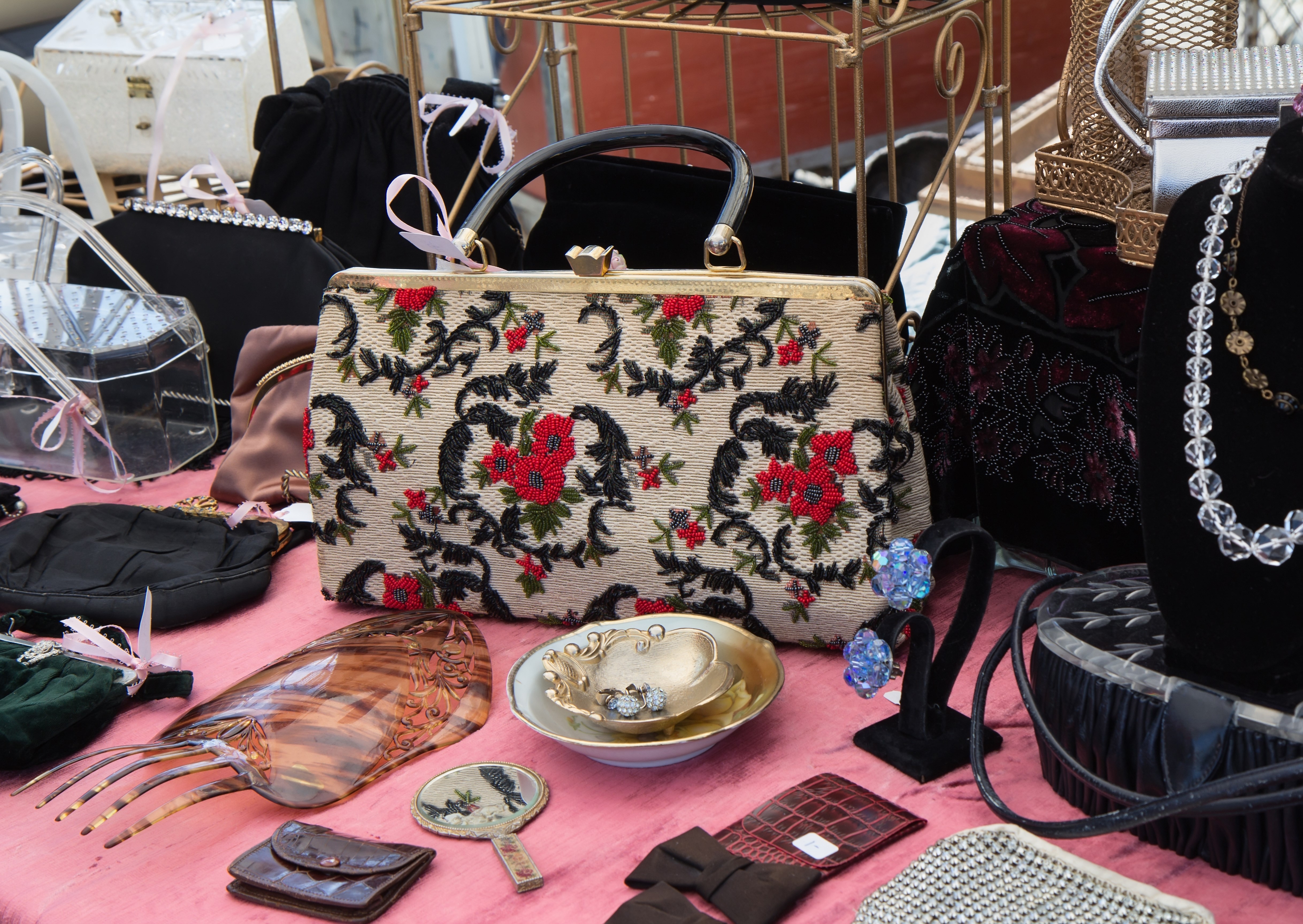 Stand with vintage embroidered purse, costume jewelry and more at flea market